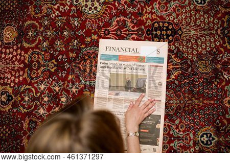 Paris, France - Sep 9 2022: Pov Woman Reading Financial Times Newspaper With Cover Featuring Russian