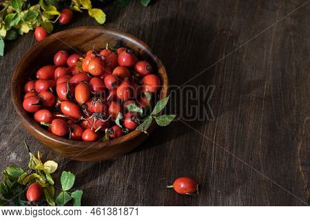 Rosehip Berries In Wooden Bowl. Rustic Wooden Background. Vertical