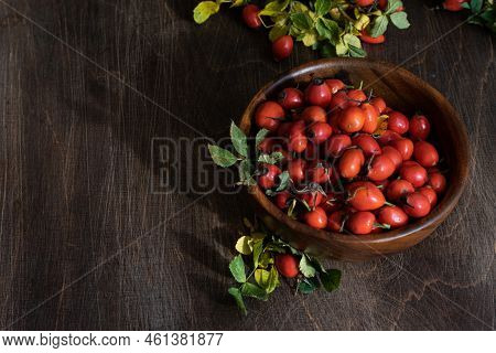 Rosehip Berries In Wooden Bowl. Rustic Wooden Background. Vertical