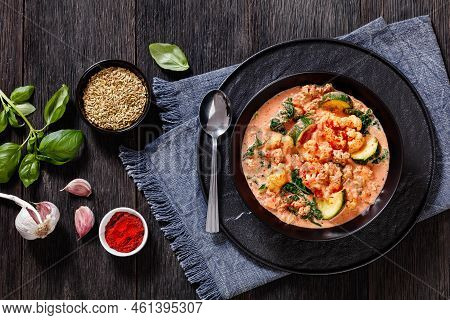 Creamy Tomato Soup With Ground Chicken, Cauliflower, Zucchini, Kale, Basil And Spices In Black Bowl 