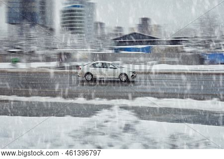 Car In Fast Motion On Winter City Street. Volkswagen Polo Moving On Urban Road During Snowfall. Mosc