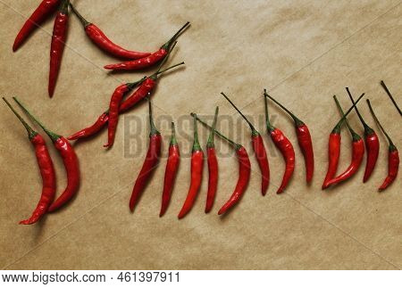 Chili Pepper On Craft Paper Background. Top View Photo Of Red Peppers On Table In A Random Position
