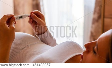 Pregnancy Fever Temperature Check. Pregnant Woman Holding Thermometer, Check Fever Flu Temperature. 
