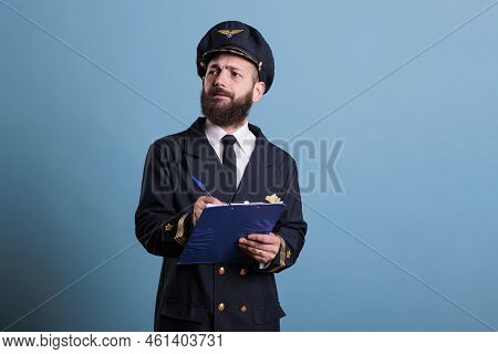 Airplane Captain Holding Clipboard, Filling Documents, Concentrated Aviator With Form. Aircraft Pilo