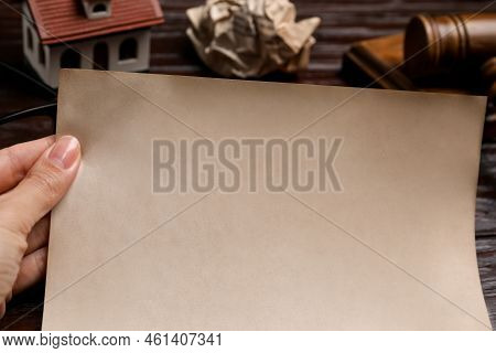 Woman Holding Last Will And Testament At Wooden Table, Closeup