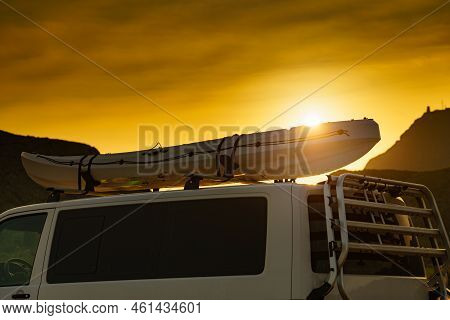 Car Van With Canoe On Top Roof Against Sunset Sky. Active Lifestyle, Vanlife Concept.
