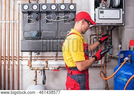Professional Heating Engineer Making Regular Gas Heating System Performance And Safety Check. Reside