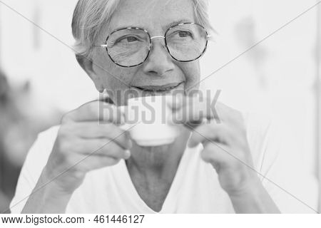 Black And White Portrait Of A Beautiful Senior Caucasian Woman With Eyeglasses As She Looks Thoughtf