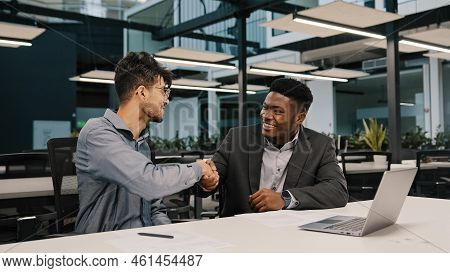 Two Diverse Men Arabian African Colleagues Co-workers Cooperate Discuss Online Project At Workplace 