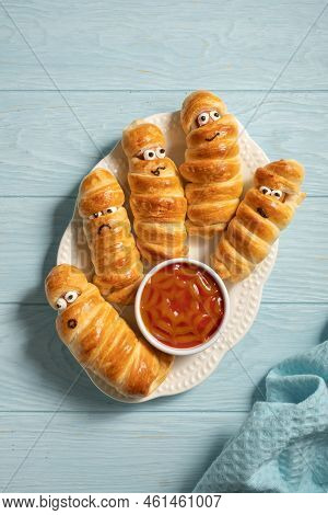 Fun Food For Kids. Mummy Sausages Scary Halloween Party Food Decoration Wrapped In Dough With A Bowl