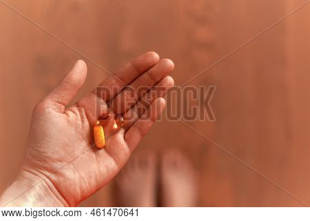 Female Hand Holding Daily Dose Of Vitamins. Omega 3 And Complex Pills. First Person Perspective, Pov