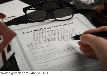Woman Signing Last Will And Testament At Black Table, Closeup