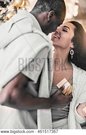 A Happy Couple Of Mulattoes Exchange Gifts With Each Other. Celebrating Joint Family Events