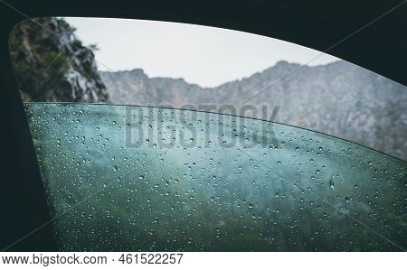 Half Opened Front Car Door Misted Window Covered With A Cold Rain Drops With A Rocky Mountains Range