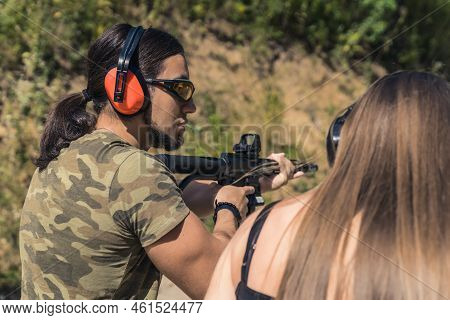 A Shooting Instructor Teaching The Backslider How To Handle A Rifle, Medium Closeup. High Quality Ph