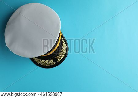 Peaked Cap With Accessories On Light Blue Background, Top View. Space For Text