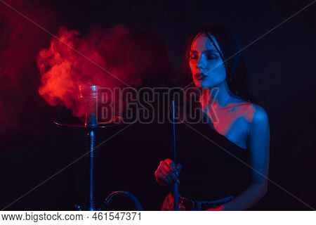 Model Girl Smokes Hookah, Sheesha. The Girl Exhales With Pleasure. Color Light