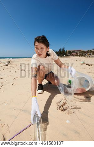 Environmental Activist Collecting Marine Debris On Beach