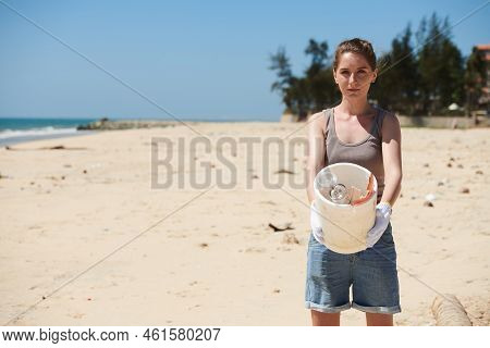 Young Woman Showing Bucket Of Garbage She Collected On Dirtybeach