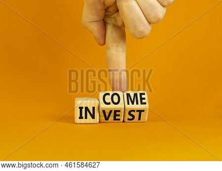 Invest Or Income Symbol. Concept Words Invest And Income On Wooden Cubes. Businessman Hand. Beautifu