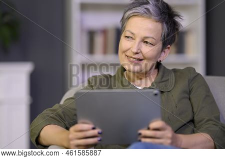 Charming Mature Aged Woman 45s With Pad Gadget In Hand Dreaming While Makes Online Shopping