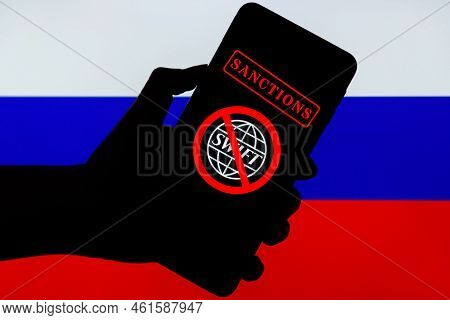 Ukraine, Kiev - February, 23 2022: Silhouette Of Black Hand Holding Mobile With Crossed Out Swift Lo
