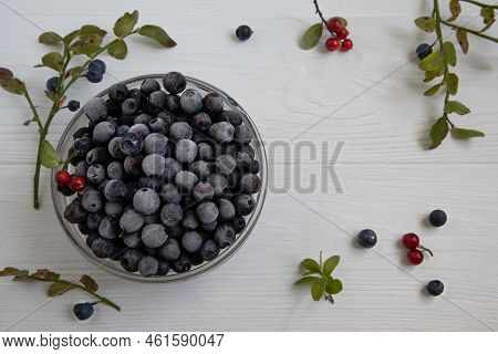 Frozen Blueberries In A Glass Bowl, Highlighted On A White Background With A Space To Copy.