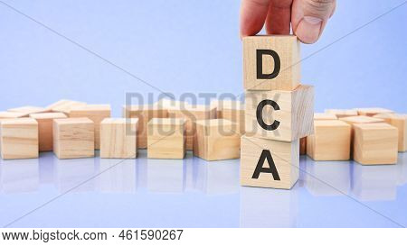 The Text Dca Is Written On Wooden Cubes On A Bright Blue Surface. Business Concept. Dca - Short For 
