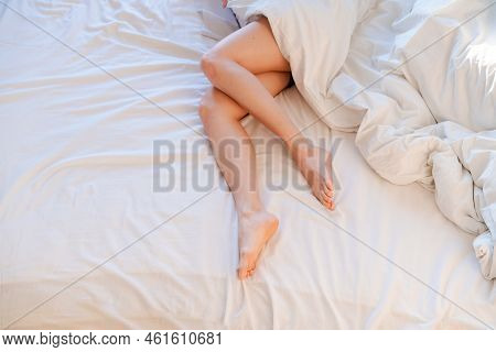 Slim, Perfect And Beautiful Crossed Womans Legs On Bed. Cropped Image Erotic Woman Lying On The Bed 