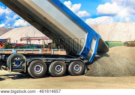 A Large Dump Truck Unloads Rubble Or Gravel At A Construction Site. Car Tonar For Transportation Of 