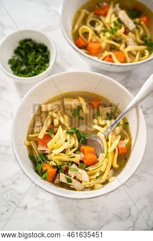 Serving Chicken Noodle Soup With Kluski Noodles In White Ceramic Soup Bowls.