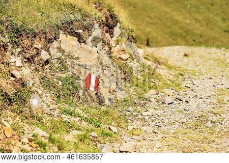 Red And White Trail Sign (trail Marker) Painted On A Stone Alongside A Hiking Footpath In Austrian A