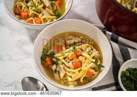 Serving Chicken Noodle Soup With Kluski Noodles In White Ceramic Soup Bowls.