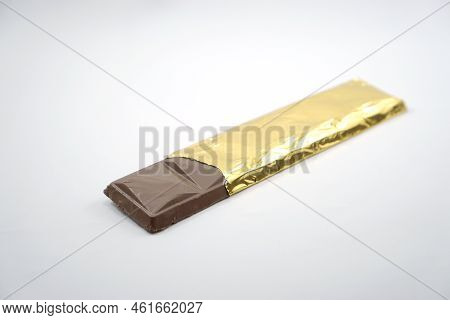 Chocolate Bar In Opened Gold Aluminum Foil Isolated On White Background