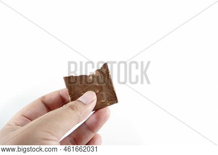 Close-up Of Hand Holding Chocolate Bar Isolated On White Background
