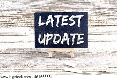 Latest Update Text On Miniature Chalkboard On Wooden Background
