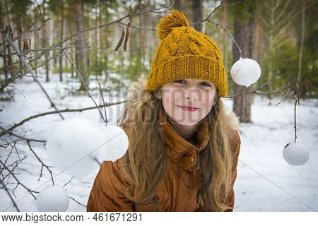 In Winter, On A Frosty Day In The Forest, A Girl Makes Snowballs With A Snowball And Decorates Tree 
