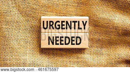 Urgently Needed Symbol. Concept Words Urgently Needed On Wooden Blocks On A Beautiful Canvas Table C