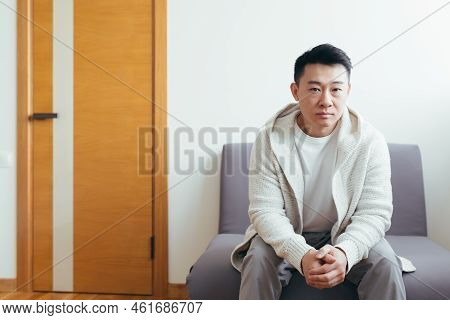 Young Asian Man Waiting For An Interview Or Meeting Sitting In The Hallway In The Waiting Room. Stud