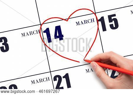 14th Day Of March. A Woman's Hand Drawing A Red Heart Shape On The Calendar Date Of 14 March. Heart 