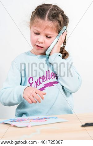 Little Girl Talking On The Phone With Her School Friends.