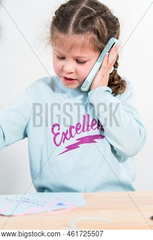 Little Girl Talking On The Phone With Her School Friends.