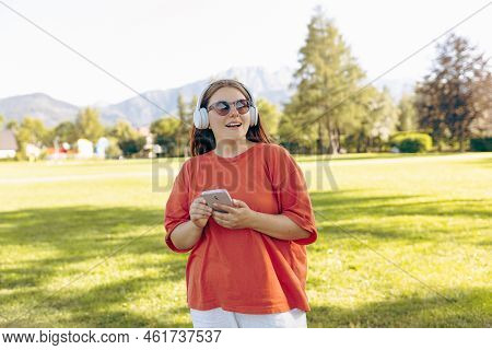 Close Up Portrait Of A Lovely Happy Young Woman In Sunglasses Listening To Music Through Wireless Ea