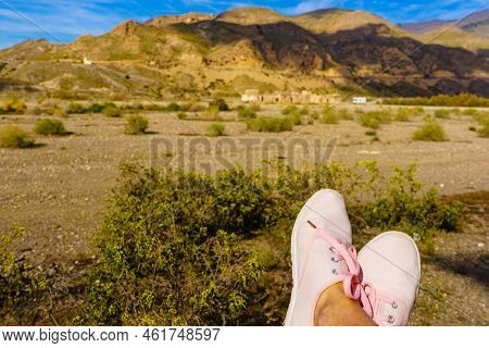Female Feet In Sierra Alhamilla Landscape, Spain. Caravan At El Chorillo Movie Location In The Backg