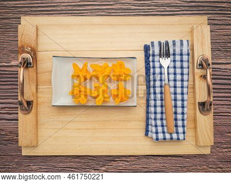 Pinched Gold Egg Yolks Or Khanom Thong Yip In The Thai Language Are Placed On A Plate With Cutlery A