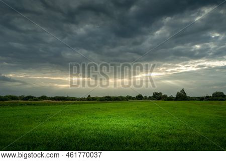 Lumen Of Sunlight On A Cloudy Sky And A Green Meadow