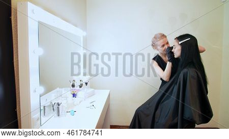Beauty Saloon. The Cosmetician In Black Rubber Gloves Hold Tweezers And Pull Out Eyebrows. Master Co