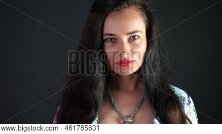 Portrait Of A Sexy Brunette Woman With Red Lips Who Eroticly And Playfully Eats Black Chocolate With