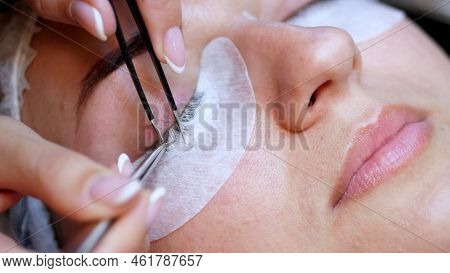 Beauty Saloon. Close-up, Procedure For Eyelash Extension. The Master Glues Each Cilium With Special 