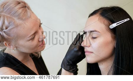 Beauty Saloon. The Cosmetician In Black Rubber Gloves Keep A Special Brush And Comb Eyebrows. Master